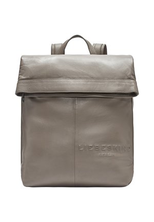 Mochila de cuero gris con cierre de solapa, que presenta un logotipo de la marca en relieve, asas ajustables y textura suave. Diseño minimalista.