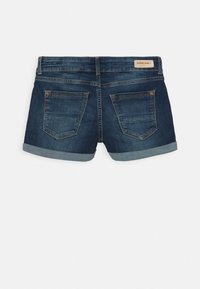 Szorty dżinsowe w ciemnoniebieskim odcieniu, z podwiniętymi mankietami i dwoma tylnymi kieszeniami. Posiadają skórzaną naszywkę z logo na pasie.