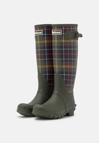 Bottes de caoutchouc étanches en vert foncé, avec un motif tartan en noir, rouge et accents jaunes, dotées d'une semelle à forte adhérence.