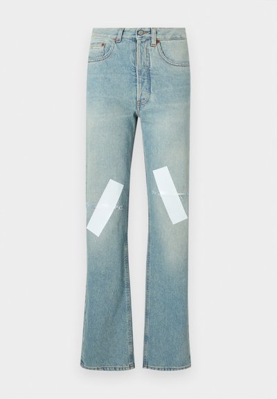 Light blue denim jeans with a flared design, featuring white patches on the knees and light distressing along the edges.