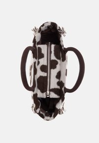 Borsa a tracolla con stampa a macchie di mucca marrone e bianco, dal texture morbida, con chiusura a zip e manici marroni. Interno foderato in tessuto marrone uniforme.