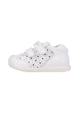 Zapato para niño pequeño blanco con doble cierre de velcro, perforaciones en forma de estrella en los laterales y puntera redonda de goma.