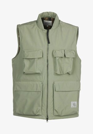 Light green sleeveless vest with multiple flap pockets and a front zipper, featuring a Carhartt logo patch at the bottom right.