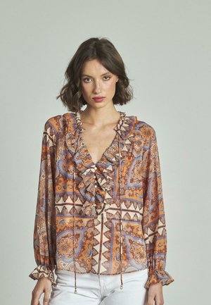 Blusa a maniche lunghe con scollatura a V, caratterizzata da balze, un motivo paisley arancione e blu, e dettagli con coulisse e perline decorative.