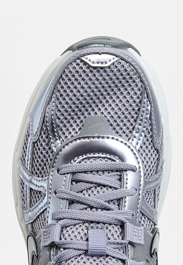 Sneaker in rete argento con tomaia testurizzata, punta rotonda e lacci. Presenta dettagli lucidi e un logo impresso sulla linguetta.