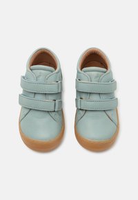 Light blue leather shoes with two Velcro straps, rounded toe, and a tan rubber sole. Smooth texture with stitched detailing along the edges.