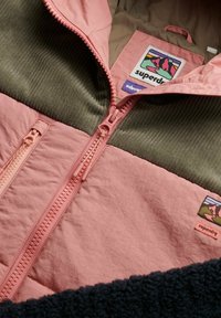 Roze en groene zip-up jas met een textuurstof, een corduroy gedeelte en een merklabel met een bergontwerp.