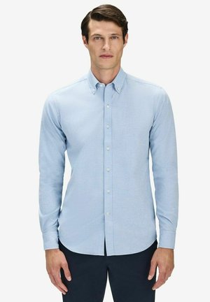 Ljusblå skjorta med knappar i en slät tygkvalitet och slim fit, med krage och långa ärmar. Kännetecknas av sin enkla design.