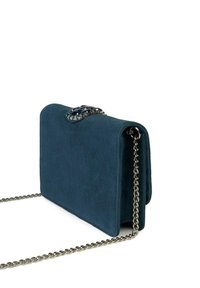 Borsa a tracolla in camoscio verde acqua con tracolla a catena argentata e chiusura decorativa con accenti blu sulla parte anteriore. Texture liscia, forma rettangolare.