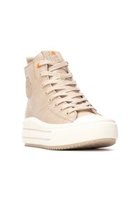 Zapatillas altas beige de cuero con acabado texturizado, que presentan un parche con el logo, acentos naranjas y una suela blanca gruesa.