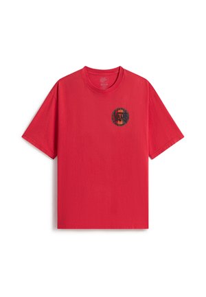 T-shirt rouge à manches courtes avec un petit logo rond Vans sur le côté gauche de la poitrine, en noir et orange.