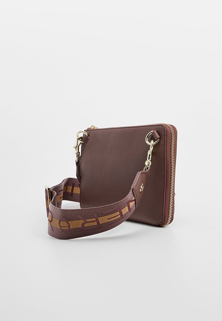 Braune Leder-Crossbody-Tasche mit strukturiertem Finish, goldenen Hardware-Elementen und einem gemusterten Riemen mit einem sich wiederholenden Design in Braun und Gold.