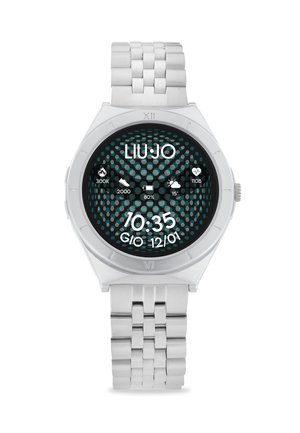 Orologio in metallo argentato con quadrante rotondo, caratterizzato da un motivo a pois nero e turchese. Il display digitale mostra l'ora e vari icone.
