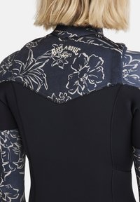 Wetsuit with black neoprene material and floral-patterned blue sleeves. Features contrasting stitching and a logo on the back neckline.