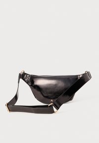 Borsa a vita in pelle nera lucida con tracolla regolabile e piccolo logo dorato sul davanti, su sfondo semplice.