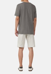 Grijze t-shirt met korte mouwen en ronde hals, gecombineerd met witte knielange shorts. Casual schoenen maken de outfit compleet. Eenvoudig, ontspannen ontwerp.