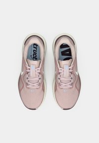 Ζευγάρι ροζ μαξιλαρωμένα αθλητικά παπούτσια Nike με λευκά λογότυπα swoosh, ανώτερα μέρος από δίχτυ και ανοιχτόχρωμες σόλες, εμφανιζόμενα από ψηλά.