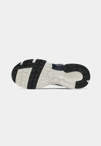 Εξωτερική σόλα παπουτσιού τρεξίματος με λευκή ενδιάμεση σόλα και μαύρη ελαστική εξωτερική σόλα με σχέδιο πέλματος για πρόσφυση και στήριξη.