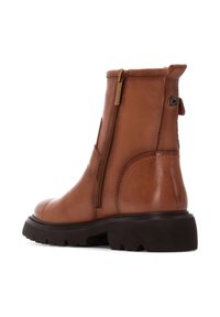 Botines de cuero marrón con cremallera lateral y suela de goma negra texturizada. Incluye una lengüeta en el talón para facilitar el calzado.