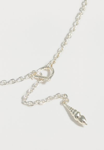 Ασημένιο κολιέ με αλυσίδα, με καρδιόσχημο κούμπωμα toggle και μικρό μενταγιόν σε σχήμα σπείρας κοχυλιού, σε λευκό φόντο.