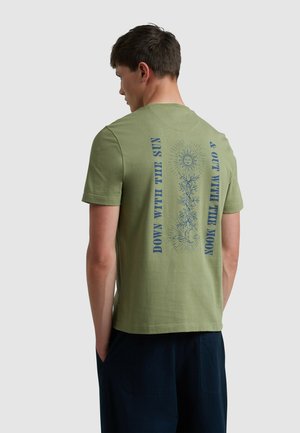 T-shirt en coton vert olive avec un design graphique central bleu comportant des motifs de soleil et de lune ainsi qu'un texte, coupe standard avec des manches courtes.