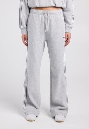 Lichtgrijze sweatpants met wijde pijpen, gemaakt van een zachte katoenmix, voorzien van zwarte zijstrepen, een elastische tailleband met trekkoord en zijzakken.