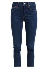 Pantalones ajustados de mezclilla azul oscuro, confeccionados en un denim suave, con una cintura de altura media, cinco bolsillos y costuras doradas con detalles de hardware en cobre.