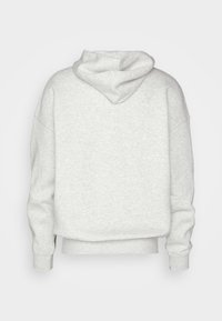 Hanorac gri din material fleece texturat, având o glugă mare, umeri lăsați și manșete ribbate. Vedere din spate care arată o croială lejera.