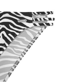 Bikini-Höschen im Schwarz-Weiß-Zebra-Muster mit einem silbernen "Venice Beach"-Label, ausgestattet mit drei Seitenriemen und strukturierten Nähdetails.