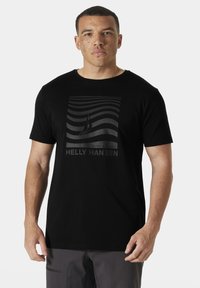 Camiseta negra de algodón con un estampado gráfico que presenta líneas onduladas blancas y un velero. El nombre de la marca "HELLY HANSEN" aparece debajo.