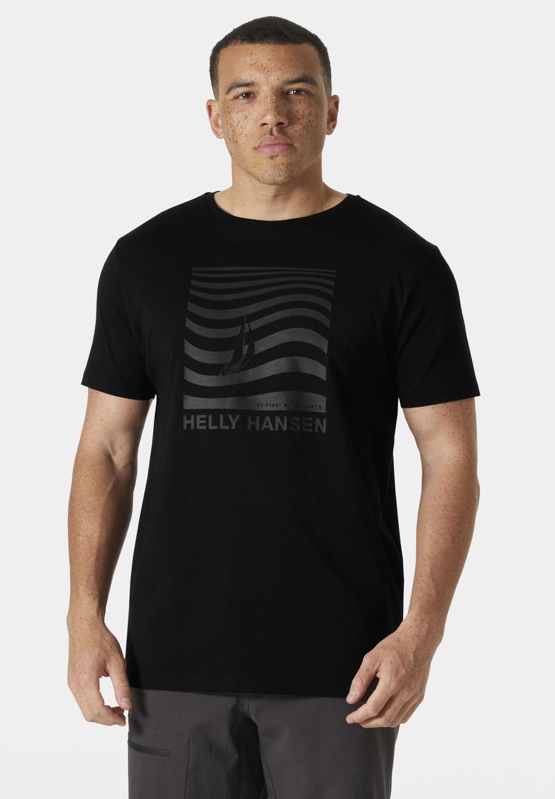 Camiseta negra de algodón con un estampado gráfico que presenta líneas onduladas blancas y un velero. El nombre de la marca "HELLY HANSEN" aparece debajo.