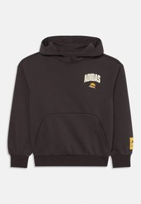 Sudadera con capucha de color gris oscuro, con un bolsillo tipo canguro, que presenta el logo blanco de Adidas y un parche amarillo con detalles de la marca en la manga.
