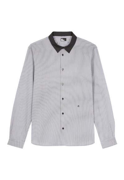 Camisa de manga larga a rayas en blanco y negro. Cuenta con un cuello negro, cierre de botones y un logo bordado cerca del dobladillo.