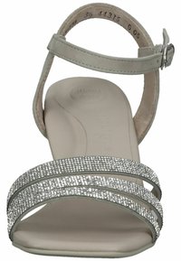 Sandale mit Riemchen aus hellgrau Leder und gepolsterter Sohle. Verfügt über drei mit silbernen Strasssteinen akzentuierte Riemen und einen geschnallten Knöchelriemen.