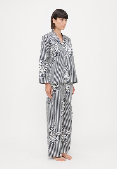 Striped pajama set in navy and white, featuring floral patterns. The top has a collar and long sleeves; pants are loose-fitting with an elastic waistband.