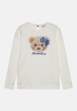 Hvid skjorte med lange ærmer med en pailletbamseansigt, der bærer en blå sløjfe, og ordet "Monnalisa" under designet.