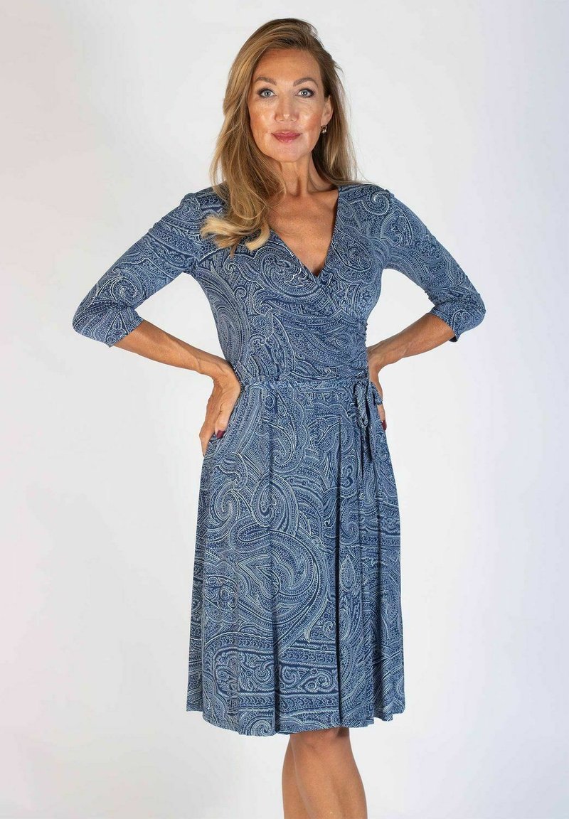 Niebieska sukienka w wzór paisley z dekoltem w serek, rękawami 3/4, dopasowanym w pasie i zwiewnym dołem. Wykonana z miękkiego, fakturowanego materiału.