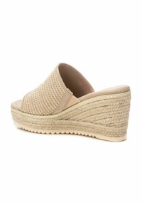 Sandalia de cuña beige con parte superior de tejido trenzado y plataforma de cuerda texturizada. Diseño de punta abierta con un revestimiento suave y suela de goma.