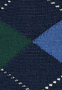 Acercamiento de una tela de punto con formas de diamante en azul oscuro, verde y azul claro, y pequeños acentos bordados en blanco.