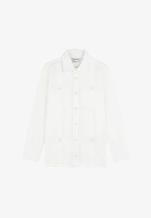 Chemise blanche à manches longues avec boutons, quatre poches sur le devant, boutons beige et col classique, étalée à plat sur un fond blanc.