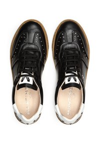 Zapatillas de piel negra con detalles perforados, acentos blancos en el talón, cordones negros y suela de goma. Logotipo en el interior del zapato.