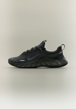 Sort atletiksko med mesh-overdel, polstret sål, trækflig på hæl og tunge samt en diskret Nike swoosh på siden.