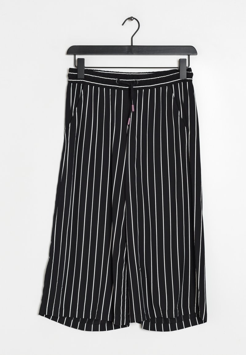 Pantalon noir à jambes larges avec des rayures blanches verticales, taille élastique avec cordon, suspendu sur un cintre noir devant un fond blanc.