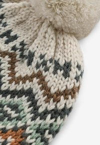 Bonnet en tricot pour l'hiver de couleur crème, gris foncé, marron et menthe. Présente un motif texturé et un pompon duveteux sur le dessus.