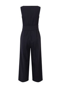 Fekete ujjatlan overál, széles lábszárral, övvel a deréknál és cipzáras záródással a háton. Simaság jellemzi a szabott fazont.