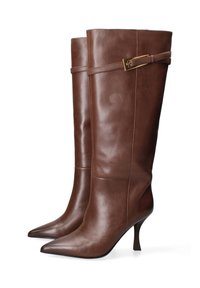 Bottes en cuir marron montantes jusqu'au genou avec un bout pointu, un talon stiletto élancé et un accent de boucle décorative près du haut. Texture lisse.