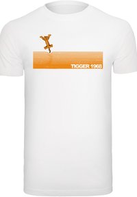 Balta medvilninė marškinėlių su oranžine Tiggerio šokančio vaizdu, su tekstu "TIGGER 1968" ir horizontaliomis oranžinėmis juostomis viršuje ir apačioje.