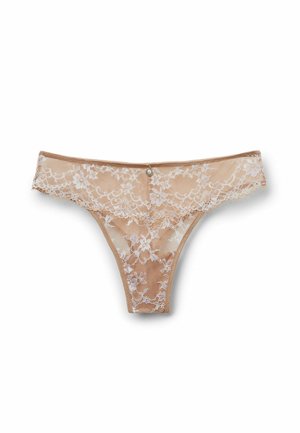 String en dentelle couleur nude avec motif floral blanc, doté d'un bouton décoratif à l'avant. Texture transparente et taille élastique. Conception légère.