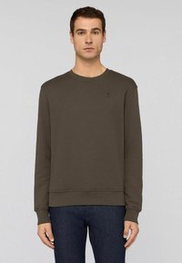 Brun sweatshirt med rund halsringning och långa ärmar. Tillverkad av en bomullsblandning, med en liten logotyp på vänster bröst.