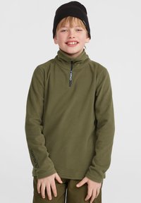 Pull-over en polaire vert avec un col zippé, portant la marque Polartec sur la manche gauche et une texture douce. Bonnet noir porté sur la tête.